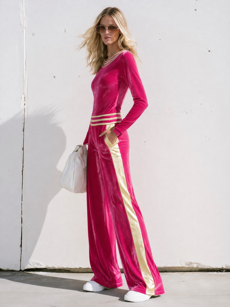 Women’s bright pink velvet T-shirt and wide-leg pants two-piece set by Oyrosy Clothing, featuring gold striped accents.