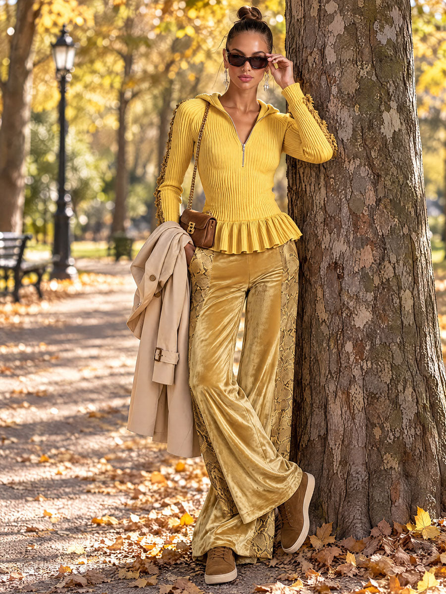 Women’s yellow knitted hooded top with ruffles paired with snakeskin velvet pants from Oyrosy Clothing.