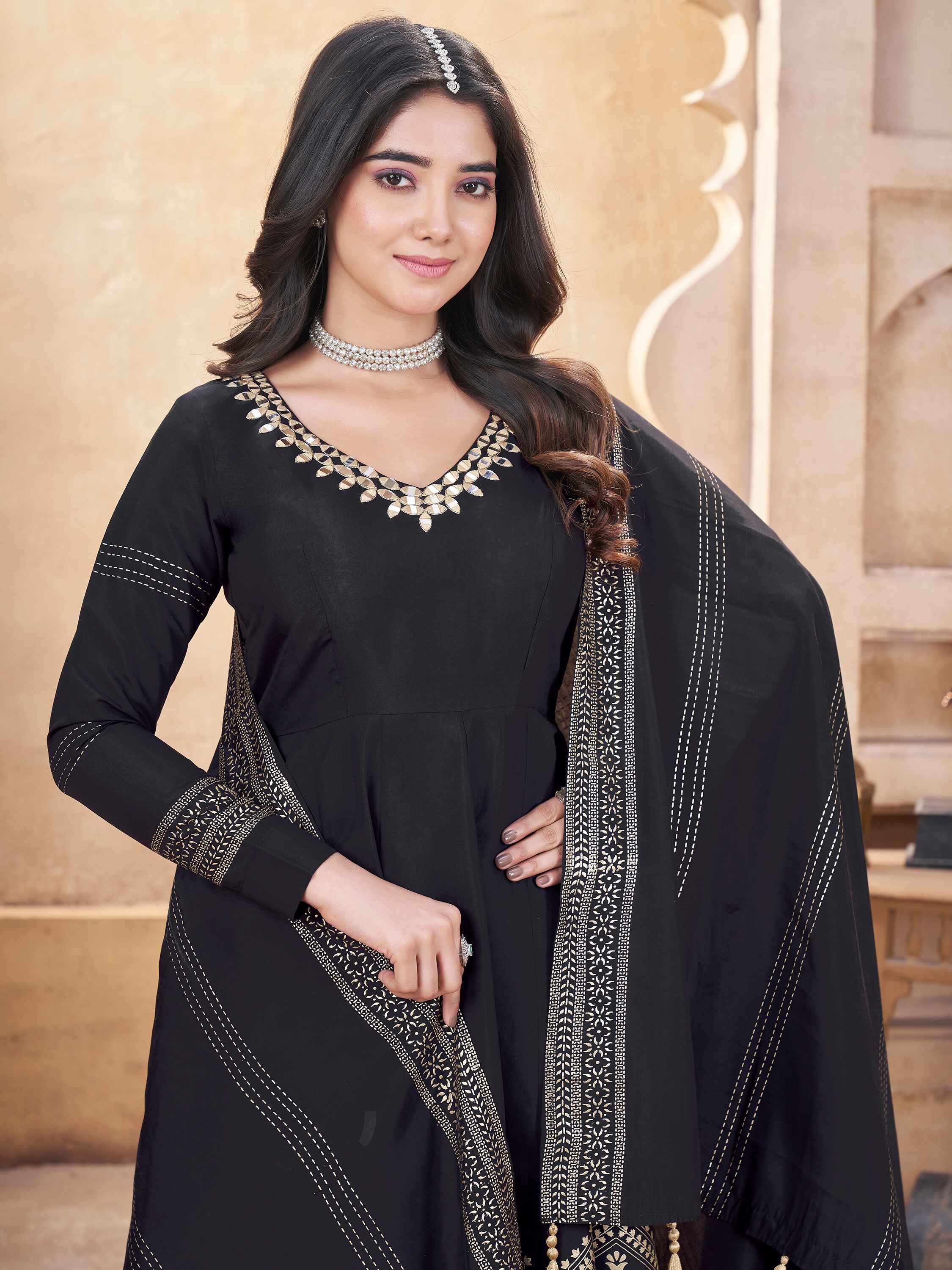 Intricate foil print and mirror work add glamour to this black anarkali suit