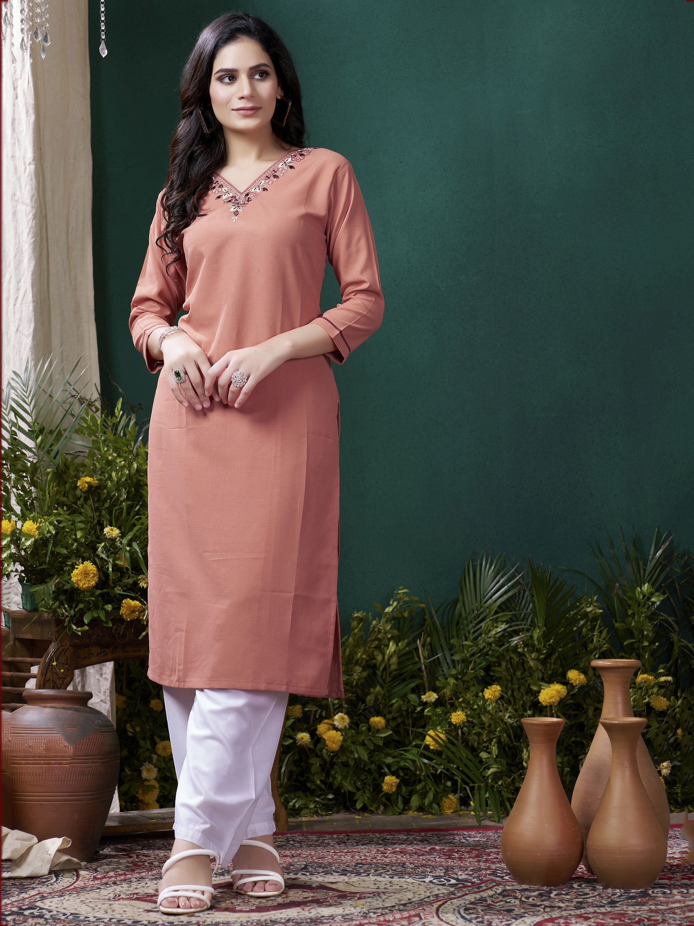 Beautiful peach-colored traditional kurti with intricate embroidery paired with matching pants