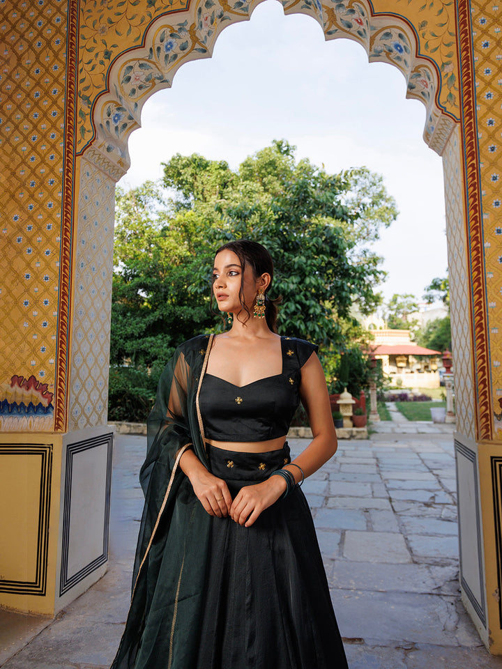  Model wearing Green Bay Embroidered Silk Lehenga Set with matching crop top and dupatta in a luxurious outdoor setting