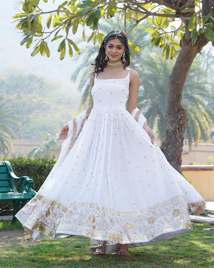 Stunning white gown with intricate embroidered floral designs cascading down the bodice and skirt, by Qivii 