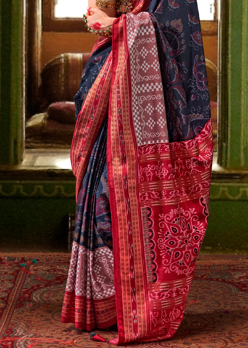 Traditional navy blue silk saree adorned with intricate patola print and golden border