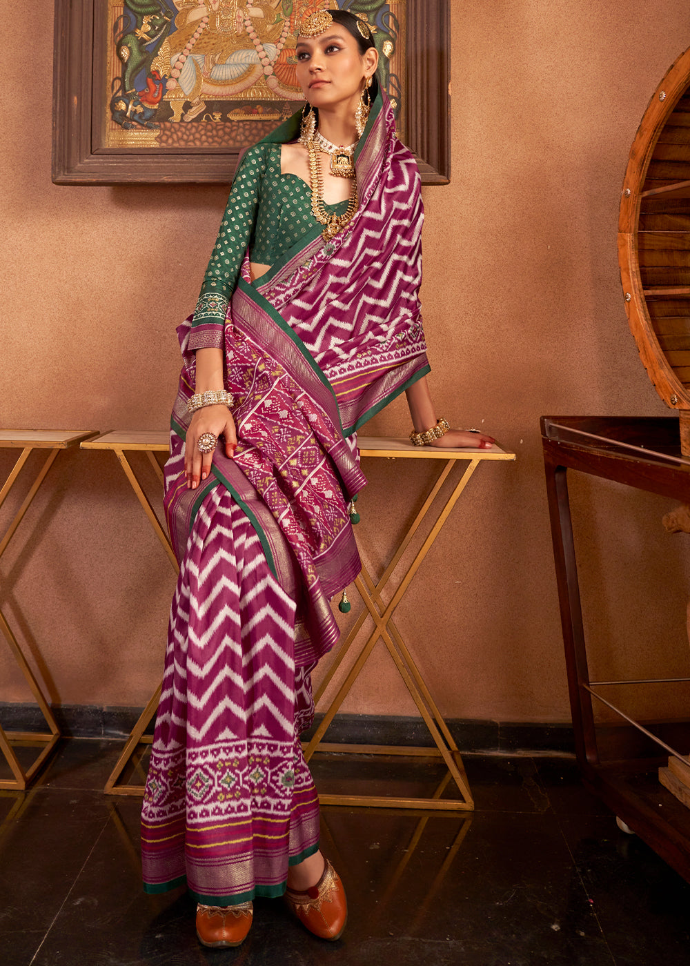 Elegant Patola Printed Silk Saree in shades of purple with contrasting blouse folded on display stand