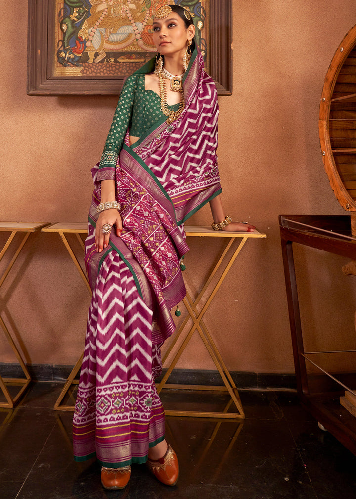 Elegant Patola Printed Silk Saree in shades of purple with contrasting blouse folded on display stand