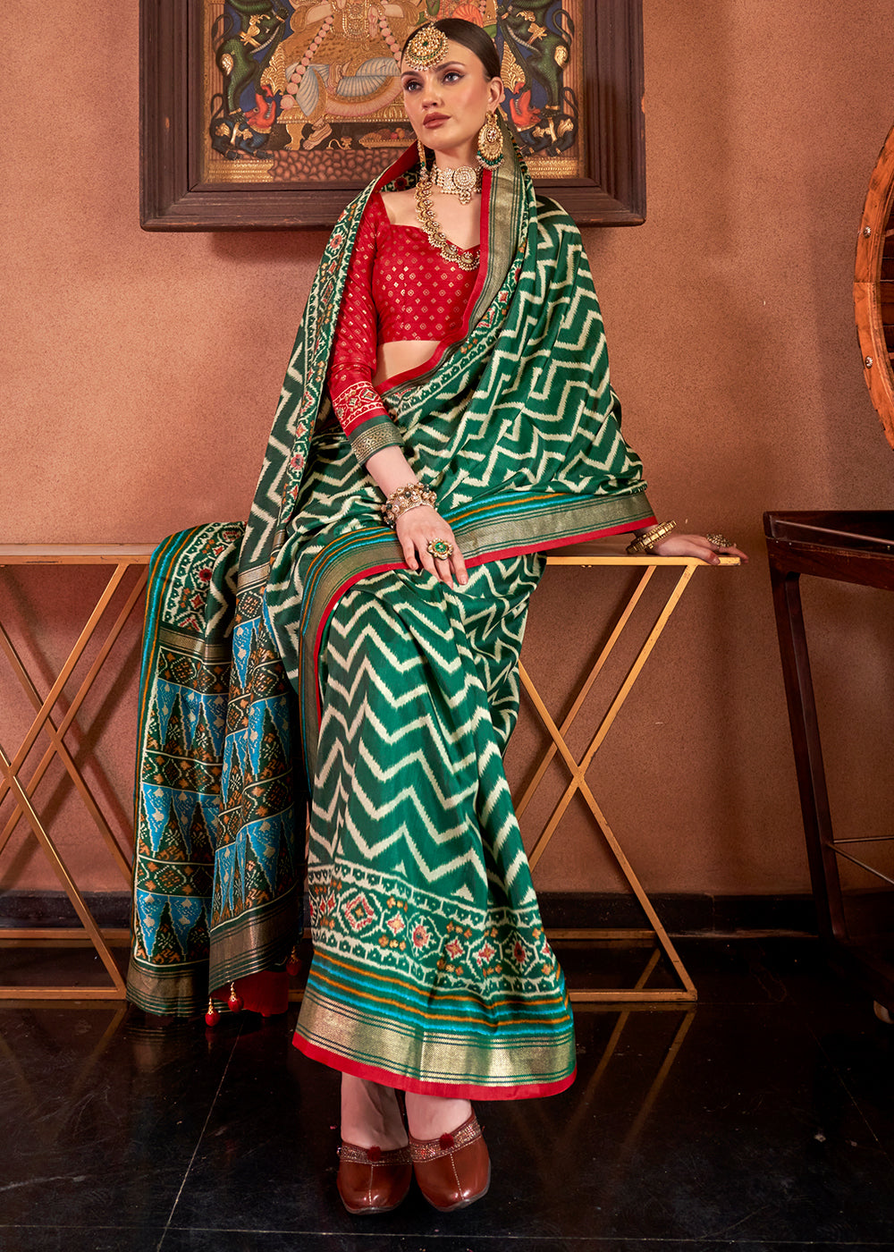 Dark green silk saree with intricate Patola print and contrasting blouse