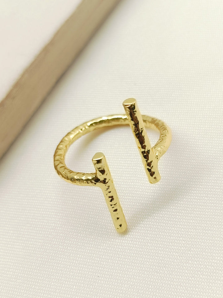 Close-up of a golden finger ring with intricate trellis design and Western-inspired details 