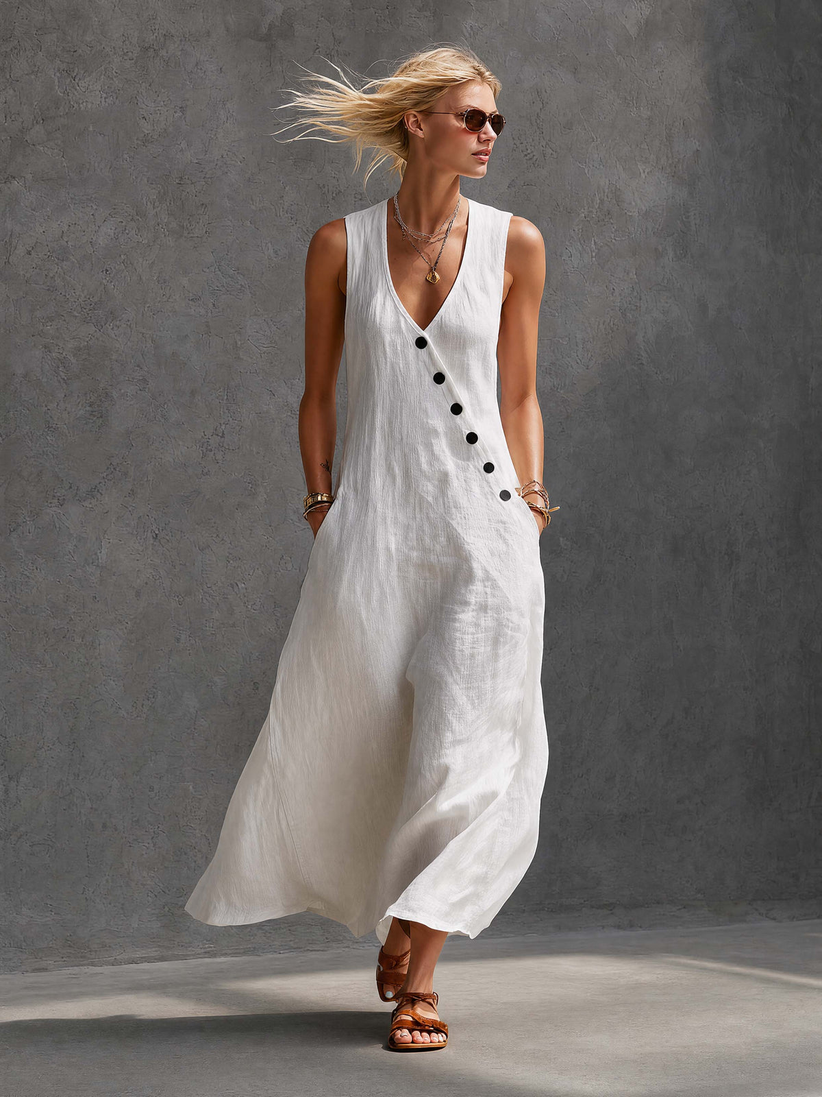 White cotton maxi dress by Oyrosy Clothing featuring a sleeveless, loose fit, V-neck, and diagonal button details.