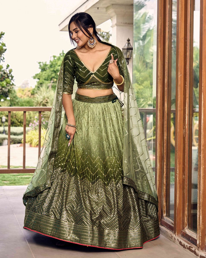 Close-up of intricate green sequins thread embroidery work on lehenga