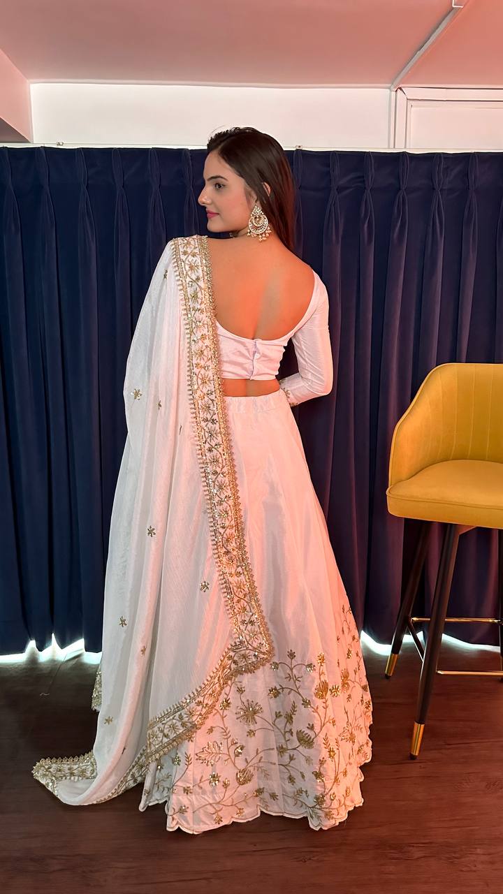 Stunning white silk lehenga adorned with intricate zari and sequins work