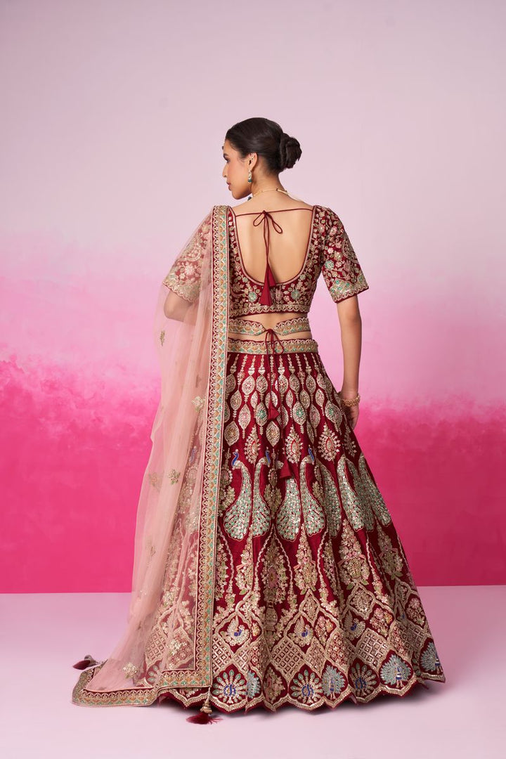 A luxurious red bridal lehenga featuring intricate embroidery, moti, sequins, and multicolor thread detailing, paired with a double dupatta