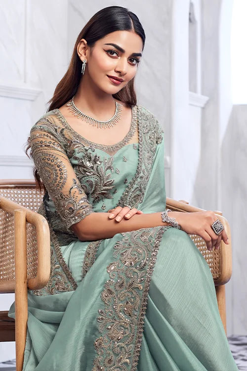 Elegant sea-green bridal saree with detailed embellishments and complementary designer blouse piece