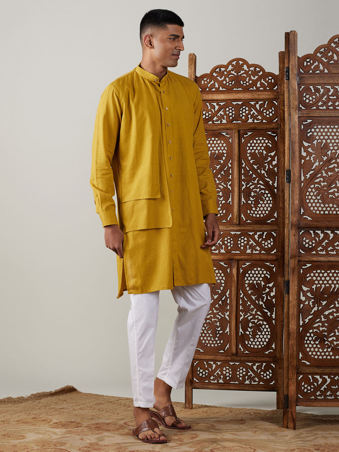 Close-up of Vastramay Men's Mustard Cotton Cool Dyable Kurta with white Pant Set on hanger