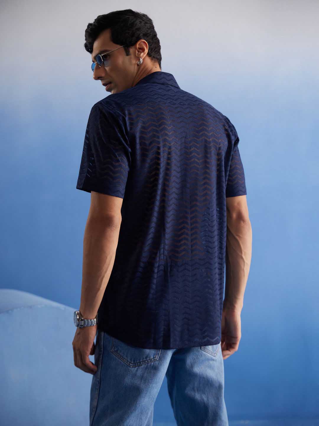 Model wearing Vastramay Men's Navy Blue Net Shirt with Denim Jeans and Sneakers