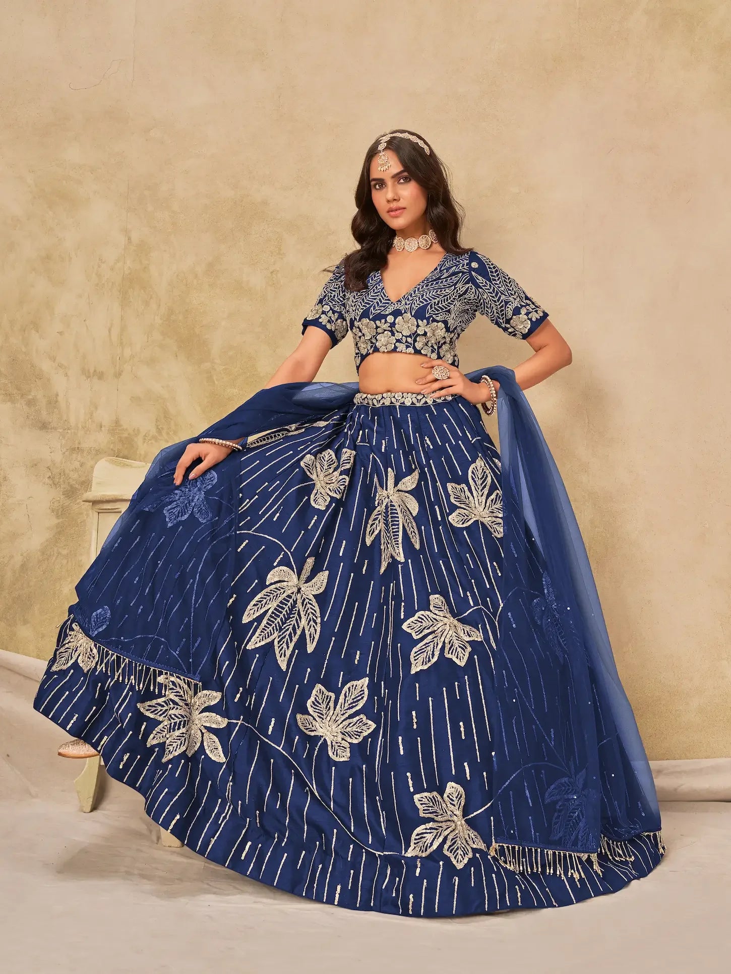 Woman wearing blue embroidered lehenga choli with floral patterns and matching dupatta