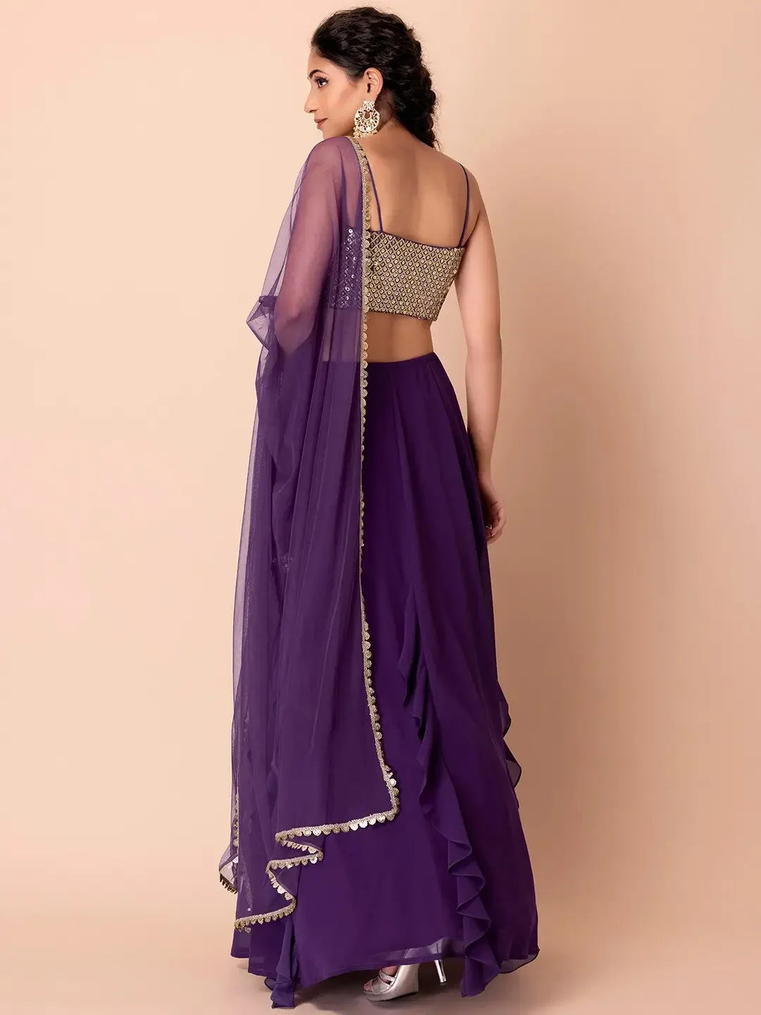 Woman in purple lehenga with embellished blouse and dupatta, back view