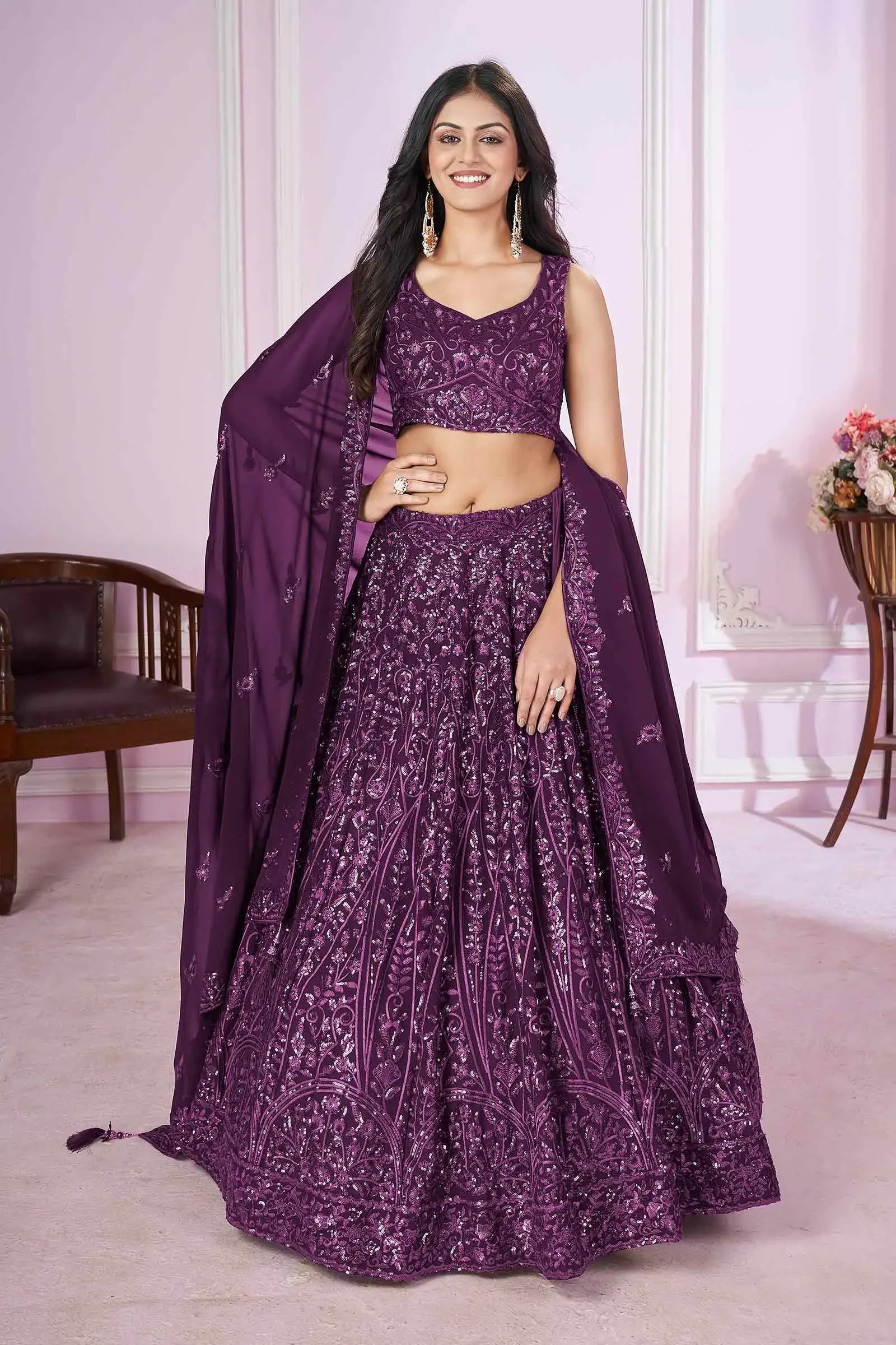 Woman in a purple embroidered lehenga choli with matching dupatta, traditional Indian attire