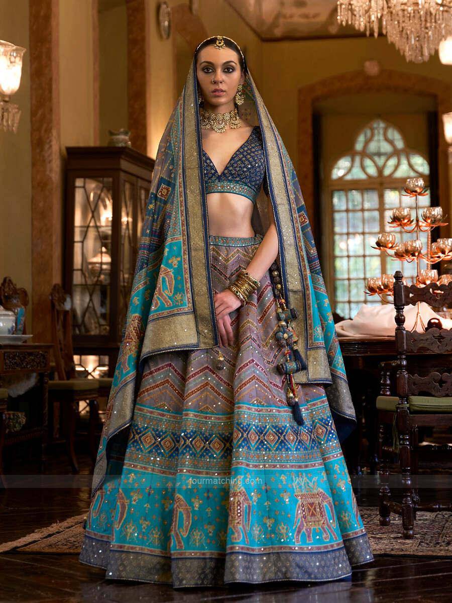 This stunning aqua blue silk bridal lehenga is perfect for a mesmerizing wedding look. The lehenga features intricate diamond swarovski and mirror work, making it a truly unique and eye-catching garment. The choli is fitted and has a deep neckline, while the lehenga is full and flared. This lehenga is sure to turn heads at any wedding.